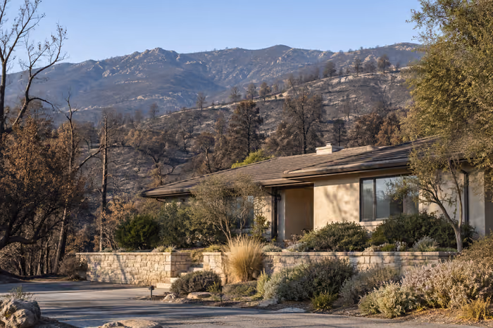 An unoccupied house beside fire-affected landscape